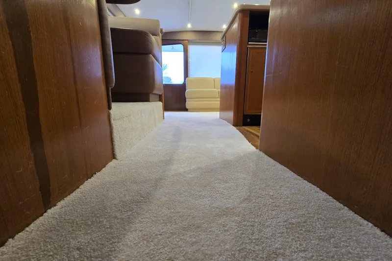 Slide: The Image of Interior view of 2004 Ocean Yachts 50 Super Sport with carpeted walkway and wooden paneling. - 19