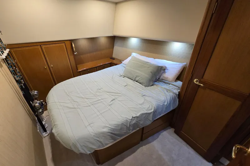 Slide: The Image of Cozy bedroom in 2004 Ocean Yachts 50 Super Sport with wooden cabinets and soft lighting. - 21