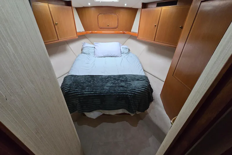Slide: The Image of Cozy bedroom in 2004 Ocean Yachts 50 Super Sport with wooden cabinets and soft bedding. - 26