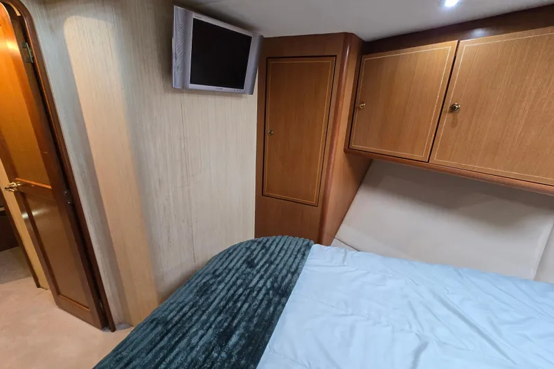 Slide: The Image of Cozy bedroom interior of 2004 Ocean Yachts 50 Super Sport with wood cabinets and mounted TV. - 27