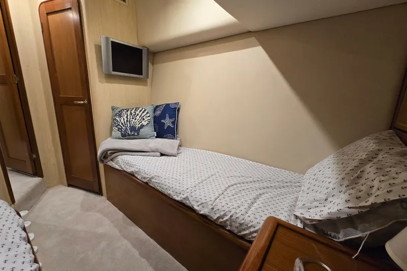 Slide: The Image of Cozy cabin interior of 2004 Ocean Yachts 50 Super Sport with nautical-themed bedding. - 32