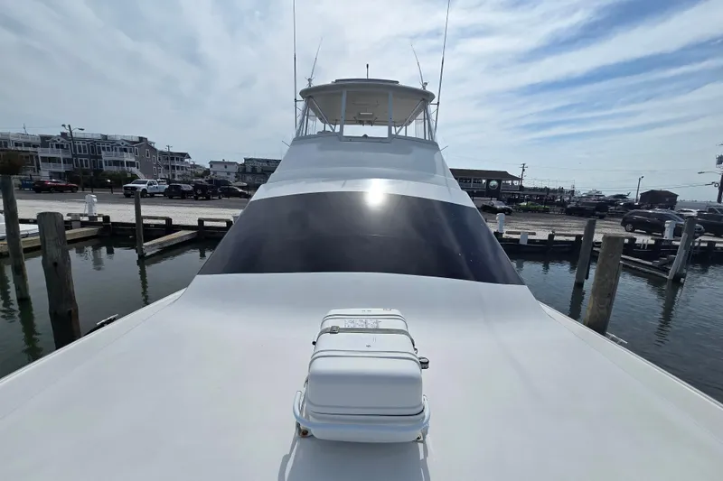 Slide: The Image of 2004 Ocean Yachts 50 Super Sport docked at marina, showcasing sleek design and spacious deck. - 40