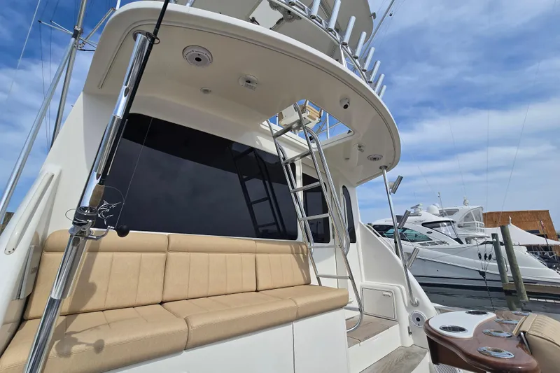 Slide: The Image of 2004 Ocean Yachts 50 Super Sport with beige seating and fishing equipment at a marina. - 48