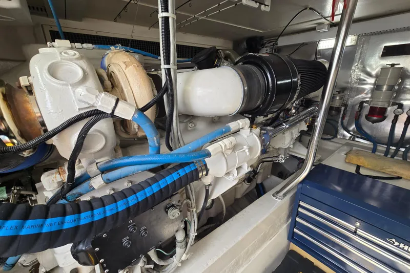 Slide: The Image of Engine room of 2004 Ocean Yachts 50 Super Sport with visible components and blue hoses. - 51
