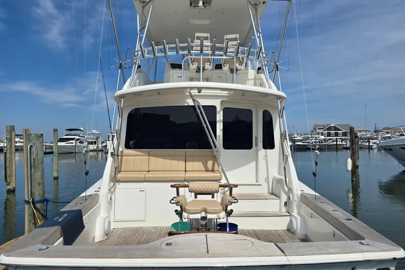 Slide: The Image of 2004 Ocean Yachts 50 Super Sport docked at marina, clear sky, fishing chair visible. - 7