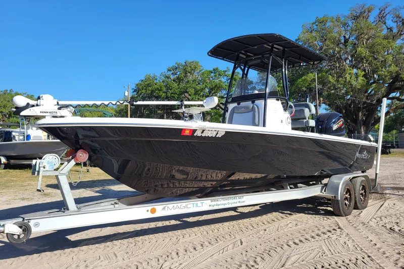 The Image of 2023 NauticStar 227 XTS boat on trailer, featuring sleek black design and modern equipment. - 1
