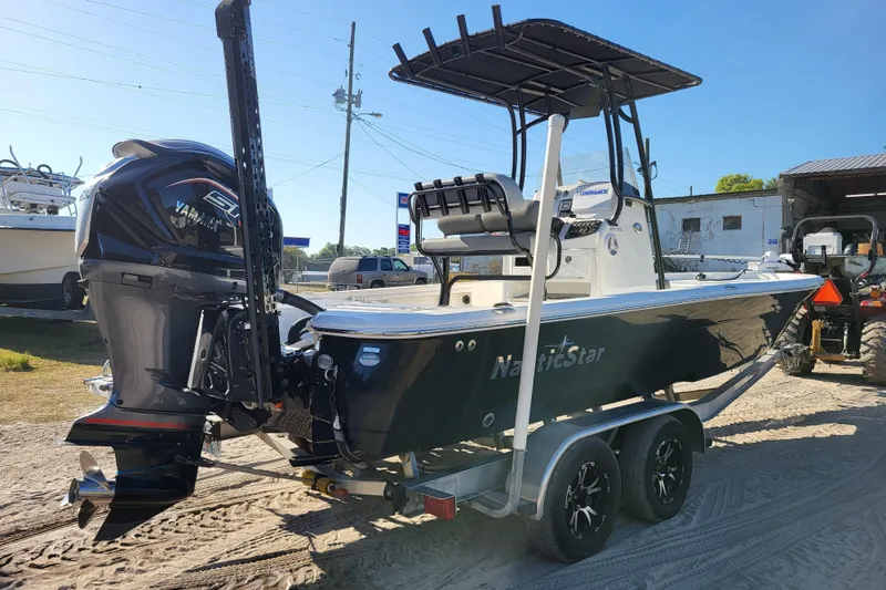 Slide: The Image of 2023 NauticStar 227 XTS boat with Yamaha engine on trailer, parked outdoors. - 3