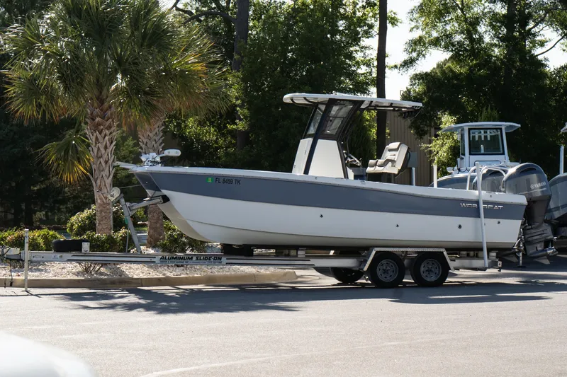 The Image of 2023 World Cat 235 CC boat on trailer, parked near palm trees. - 1