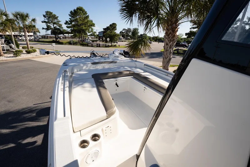 Slide: The Image of 2023 World Cat 235 CC boat interior with seating, parked near palm trees. - 10