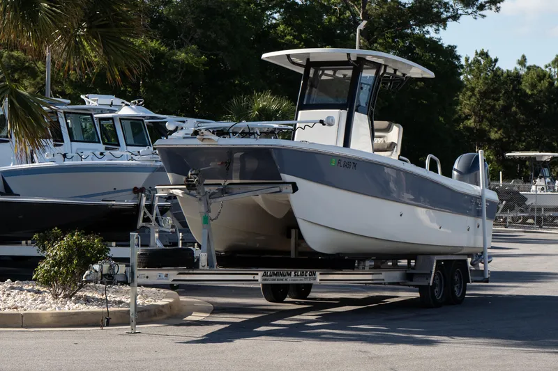 Slide: The Image of 2023 World Cat 235 CC boat on trailer in marina setting. - 3