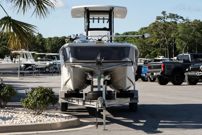 Slide: The Image of 2023 World Cat 235 CC boat on trailer in parking lot, surrounded by vehicles and greenery. - 4