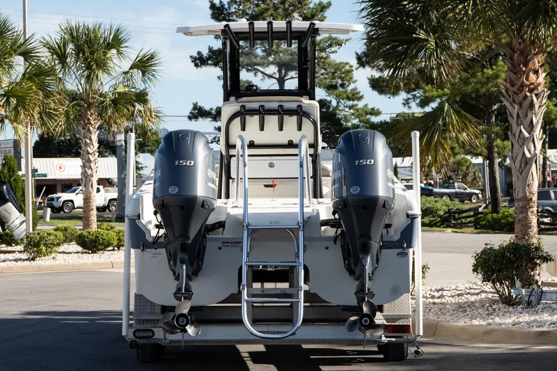 Slide: The Image of 2023 World Cat 235 CC boat with dual Yamaha 150 engines, parked near palm trees. - 6