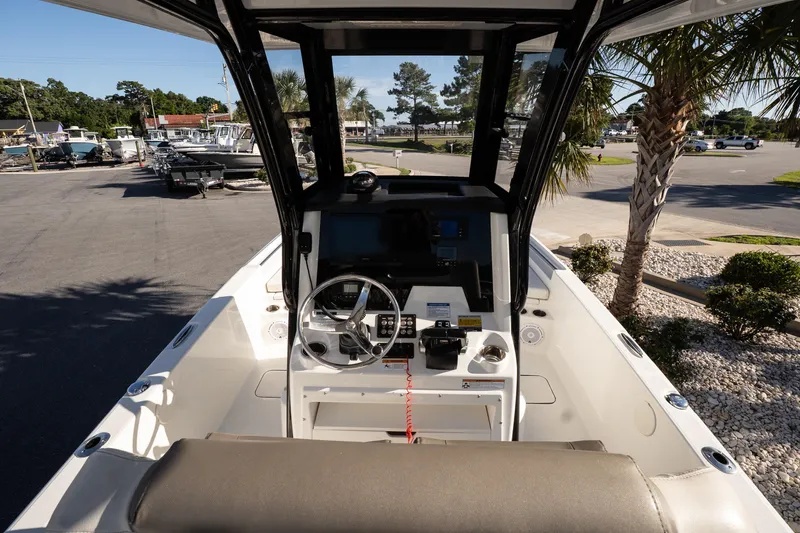 Slide: The Image of 2023 World Cat 235 CC boat cockpit with steering wheel and control panel. - 9
