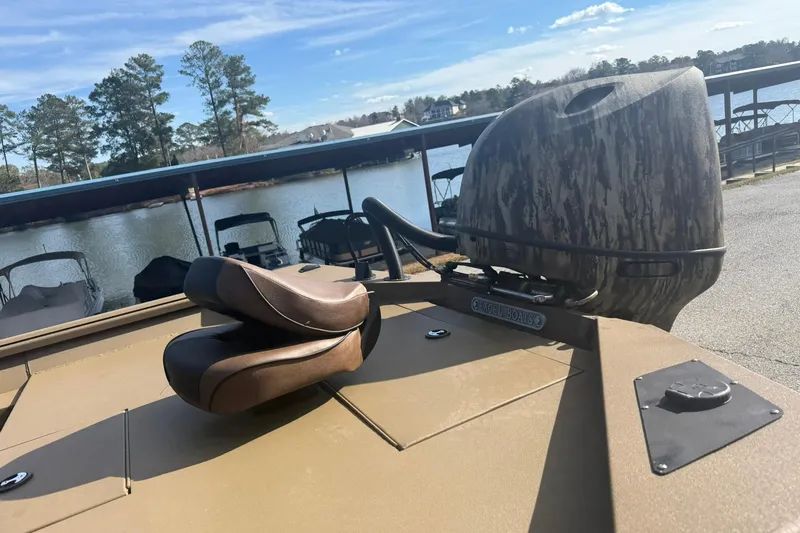 Slide: The Image of 2026 Excel 206 Stalker CC boat with camo motor cover, docked by a serene lake. - 4