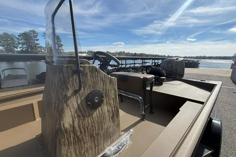 Slide: The Image of 2026 Excel 206 Stalker CC boat with camouflage design, docked by a scenic lake. - 7
