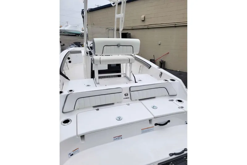 Slide: The Image of 2024 Yamaha Boats 190 FSH Sport, sleek white deck with seating and storage compartments. - 3
