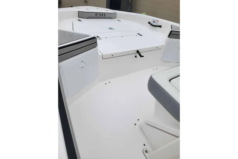 Slide: The Image of 2024 Yamaha Boats 190 FSH Sport interior, showcasing sleek white seating and storage compartments. - 7