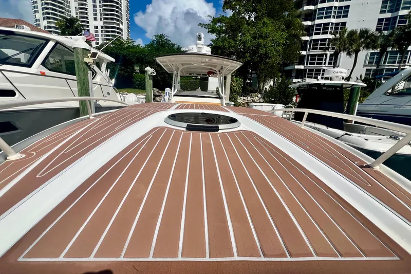 Slide: The Image of 2011 Deep Impact 36 Open boat docked, showcasing sleek deck design and nearby yachts. - 11