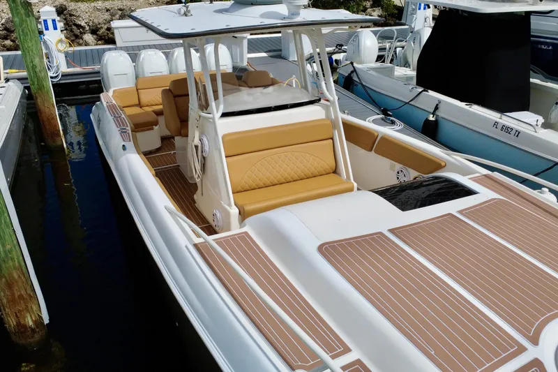 Slide: The Image of 2011 Deep Impact 36 Open boat docked, featuring tan seating and sleek design. - 13