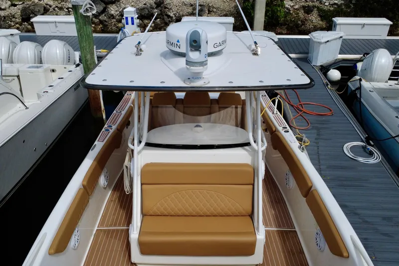 Slide: The Image of 2011 Deep Impact 36 Open boat docked, featuring tan seating and Garmin equipment. - 14