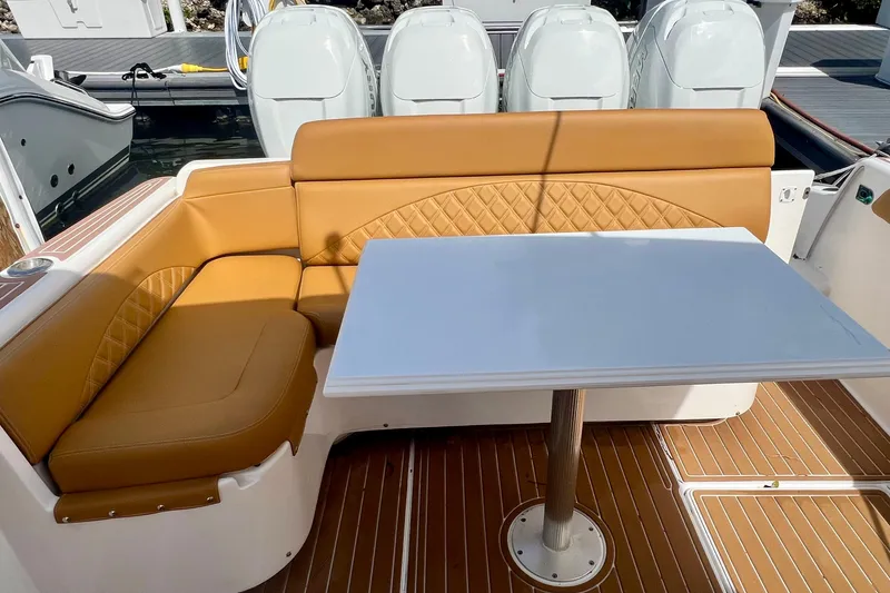 Slide: The Image of Luxurious seating area on 2011 Deep Impact 36 Open boat with tan upholstery and white table. - 23