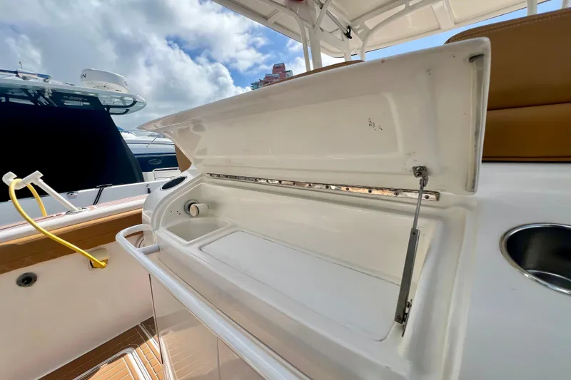 Slide: The Image of Open storage compartment on a 2011 Deep Impact 36 Open boat under a cloudy sky. - 28