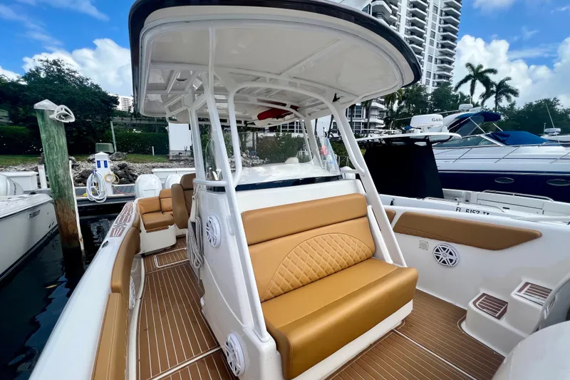 Slide: The Image of 2011 Deep Impact 36 Open boat with tan seating, docked near luxury yachts. - 36