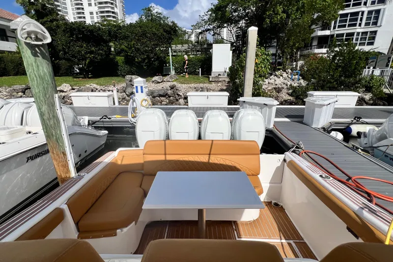 Slide: The Image of 2011 Deep Impact 36 Open boat with tan seating and table at a marina. - 50
