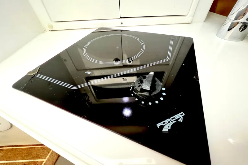 Slide: The Image of Ceramic cooktop on 2011 Deep Impact 36 Open boat, featuring sleek black design. - 53