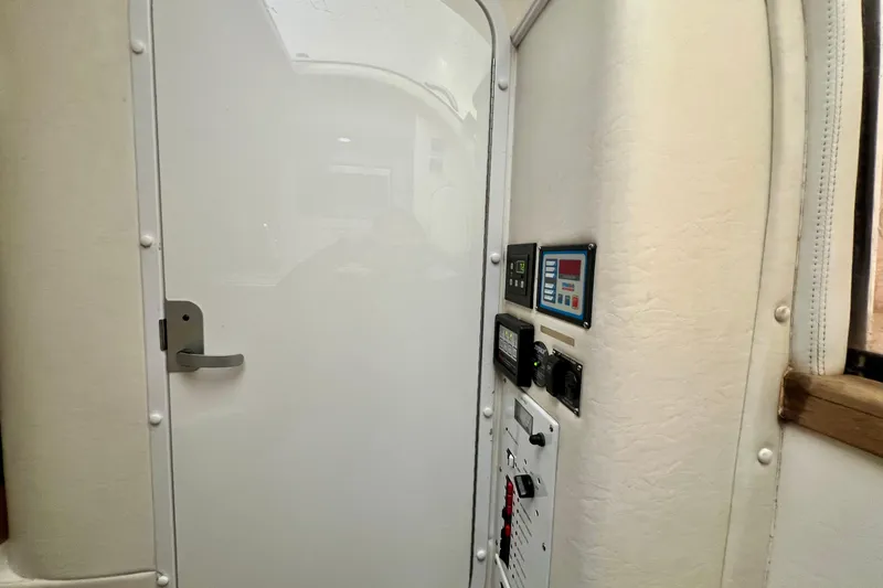 Slide: The Image of Interior view of a 2011 Deep Impact 36 Open boat, featuring a white door and control panels. - 55