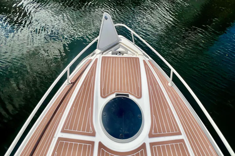 Slide: The Image of Bow view of 2011 Deep Impact 36 Open boat on water, featuring sleek deck design. - 7