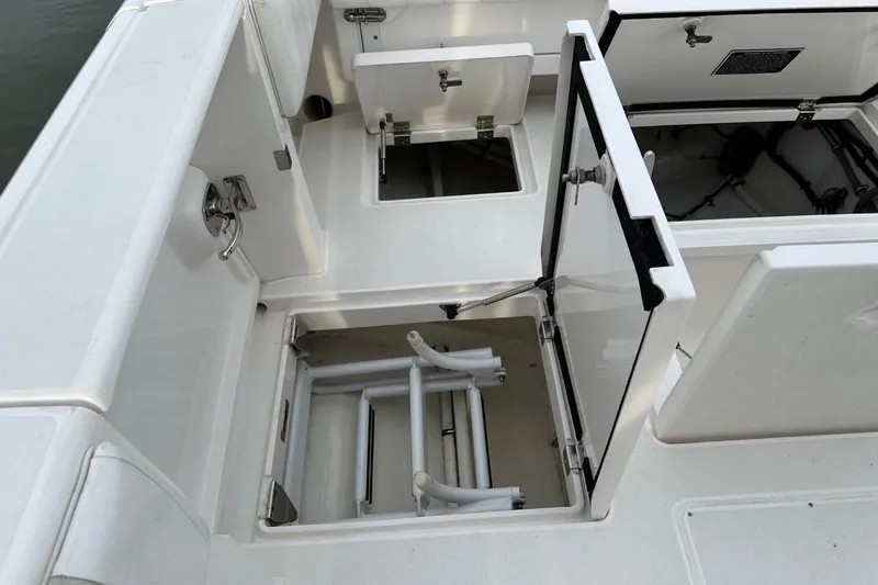 Slide: The Image of 2013 Intrepid 375 Center Console storage compartments with open hatches and visible equipment. - 37