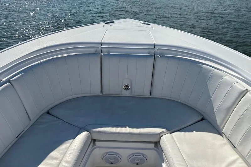 Slide: The Image of 2013 Intrepid 375 Center Console boat with white cushioned seating on calm water. - 20