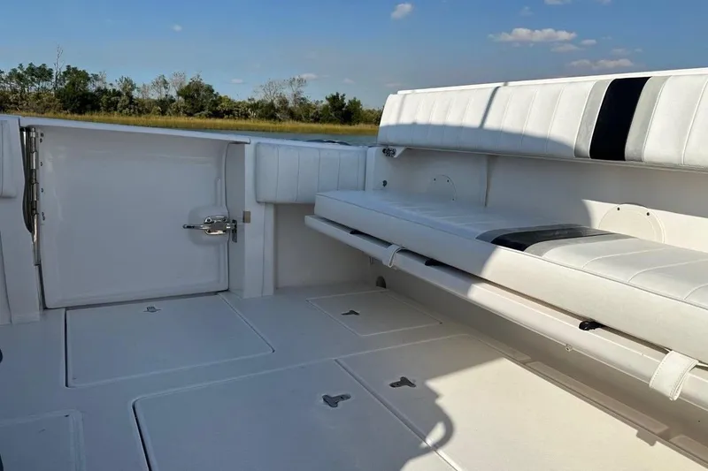 Slide: The Image of 2013 Intrepid 375 Center Console boat interior with white seating and storage compartments. - 32