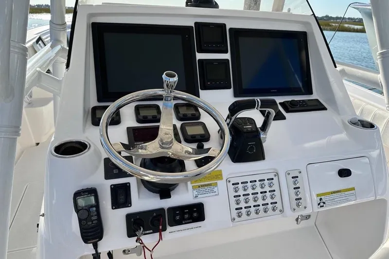 Slide: The Image of Control panel of a 2013 Intrepid 375 Center Console boat with steering wheel and navigation screens. - 13