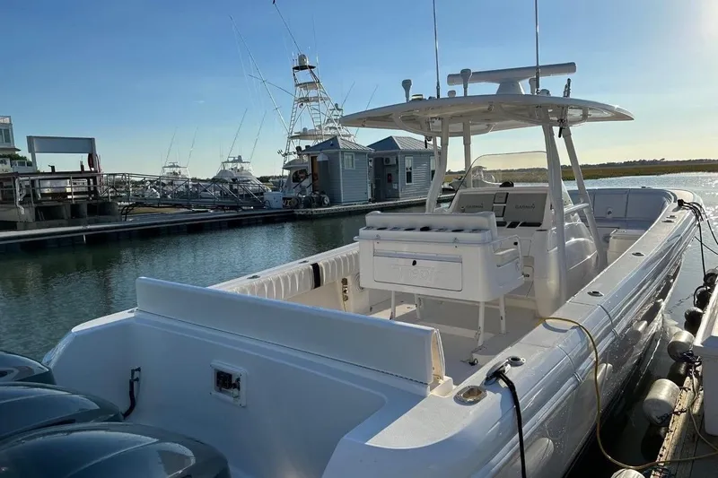 Slide: The Image of 2013 Intrepid 375 Center Console boat docked at marina under clear blue sky. - 6