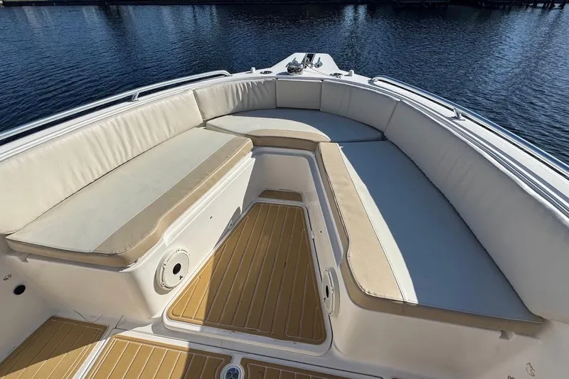 Slide: The Image of 2014 Stamas 317 Tarpon boat interior with cushioned seating and wooden deck. - 19