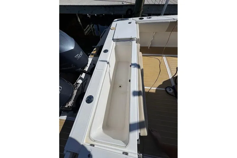 Slide: The Image of 2014 Stamas 317 Tarpon boat deck with open storage compartment and dual engines. - 49