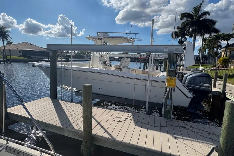 Slide: The Image of 2014 Stamas 317 Tarpon boat docked by waterfront, under clear sky with palm trees. - 52