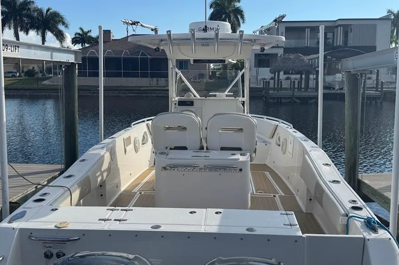 Slide: The Image of 2014 Stamas 317 Tarpon boat docked by waterfront homes, featuring spacious deck and seating. - 55