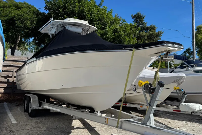 Slide: The Image of 2014 Stamas 317 Tarpon boat on trailer, covered, parked outdoors. - 59