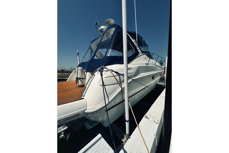 Slide: The Image of 1999 Cranchi Endurance 39 yacht docked, featuring sleek design and blue canopy under clear sky. - 35
