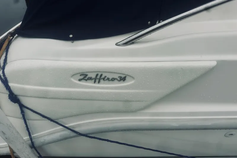 Slide: The Image of 1999 Cranchi Zaffiro 34 boat side view with logo and raindrops. - 36