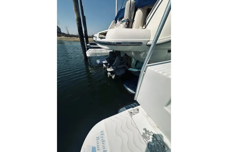 Slide: The Image of 1999 Cranchi Zaffiro 34 boat docked, showing stern and outboard motor in water. - 37