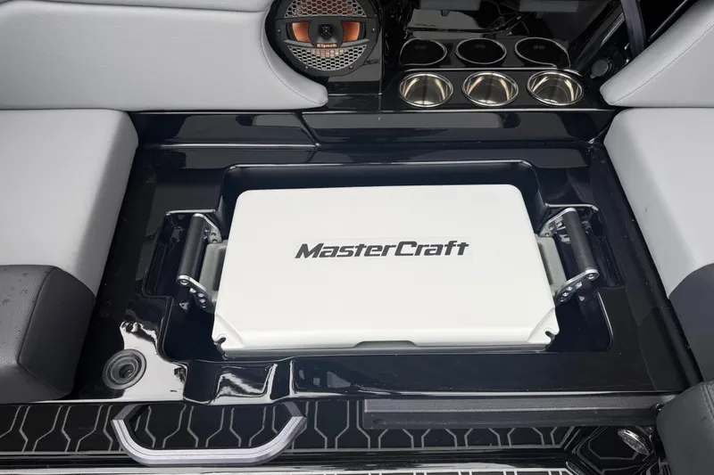 Slide: The Image of 2025 MasterCraft NXT23 boat interior with branded cooler and speaker system. - 16