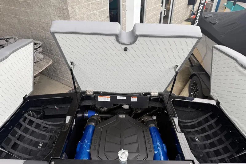 Slide: The Image of 2025 MasterCraft NXT23 boat engine compartment with Ilmor engine, open hatches, and storage areas. - 21
