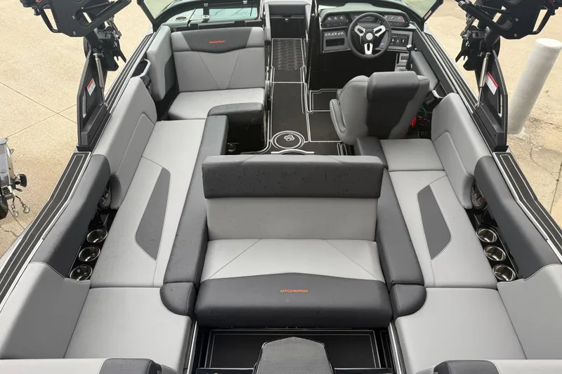 Slide: The Image of 2025 MasterCraft NXT23 boat interior with gray seating and modern dashboard design. - 27