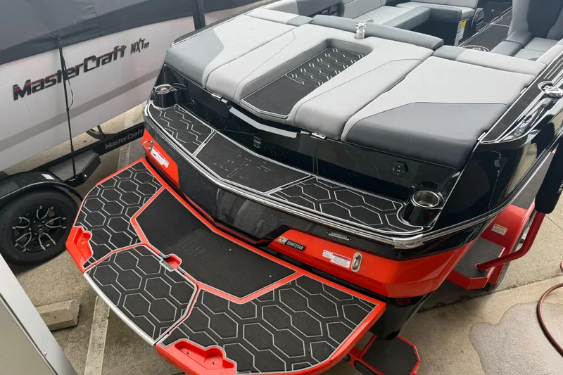 Slide: The Image of 2025 MasterCraft NXT23 boat with sleek design and modern seating, showcased on a trailer. - 28