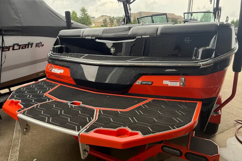 Slide: The Image of 2025 MasterCraft NXT23 boat with vibrant red and black design, featuring a spacious swim platform. - 29