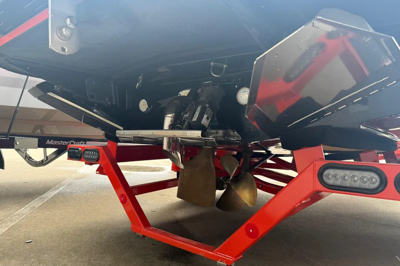 Slide: The Image of 2025 MasterCraft NXT23 boat underside with propeller and red trailer. - 31